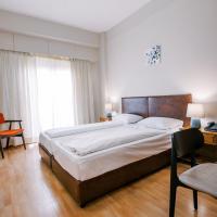 a bedroom with a large bed and a chair at Hotel Cronos, Arta