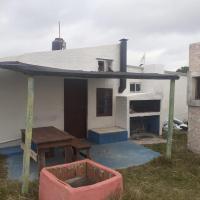 a house with a table and a picnic table in front of it at A l m a, Cabo Polonio