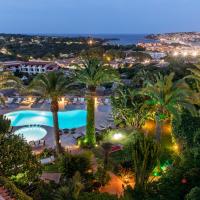 a view of a resort with palm trees at night at Hotel Balocco, Porto Cervo