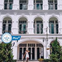 a woman standing in front of a white building at Casa Blanca Boutique Hotel - SHA Plus, Phuket Town
