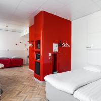 a room with a bed and a table and a red wall at Omena Hotel Tampere