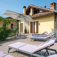 a patio with lounge chairs and an umbrella and a house at Locazione Turistica Ortondo B&B, Cortiglione