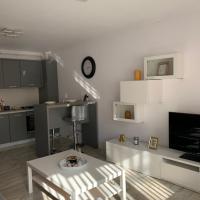 a white living room with a table and a tv at Complex Rezidential Ana, Caransebeş