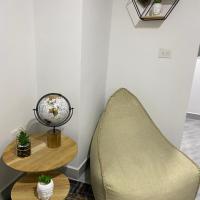 a living room with a chair and a table at Aparta estudio Amoblado Sabaneta Colombia. Moderno, céntrico y cómodo.