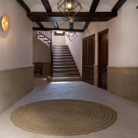 a hallway with a spiral staircase and a rug on the floor at CASA RURAL ADUANA, Rubielos de Mora