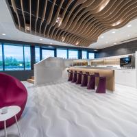 a lobby with a purple chair and a bar at prizeotel Bern-City