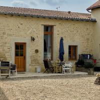 a stone house with a patio with a table and chairs at Loire Escapes - Le Grenier, Berrie
