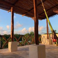 a pavilion with a wooden roof with hammocks at Casa Delfín Tulum, Macario Gomez
