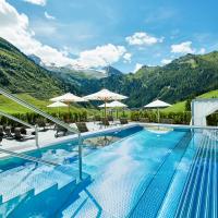 a hotel swimming pool with mountains in the background at Hotel Berghof Crystal Spa & Sports, Tux