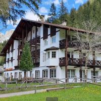 a large white building with a balcony at Park Hotel Faloria, Canazei