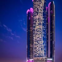 a tall building with purple lights on it at night at Paramount Hotel Dubai