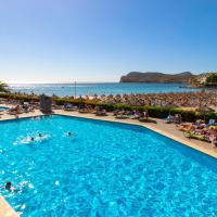a swimming pool next to a beach with people in it at Hotel Vibra Beverly Playa, Paguera