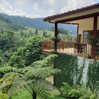 a house with a balcony and plants on a hill at Lodge Paraíso Verde, Manizales