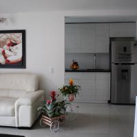 a living room with a white couch and a kitchen at Near El Poblado,New Modern,Turco,Jacuzzi & Pools, Sabaneta