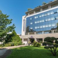 an office building with a lawn in front of it at Golden Tulip Aix les Bains - Hotel & Spa, Aix-les-Bains