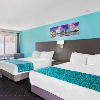 two beds in a hotel room with blue walls at Howard Johnson by Wyndham Gananoque