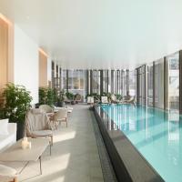 a pool in the middle of a building with chairs at Pan Pacific London