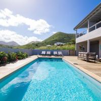 a swimming pool with a deck and a house at Villa Jwi Lavi Boutique Hotel, Saint Martin