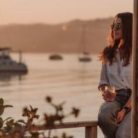 a woman sitting on a bench with a glass of wine at The Lofts Boutique Hotel, Knysna