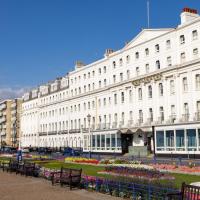 a large white building with benches in front of it at The Burlington Hotel, Eastbourne