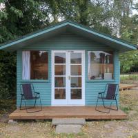 a blue tiny house with two chairs on a deck at Maid Marian's Lodge, Nottinghamshire, East Bridgford