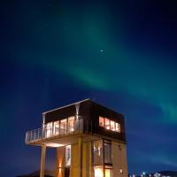 a house with the aurora in the sky at Converted Water Tower, Grindavík
