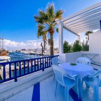 a table and chairs on a balcony with a view of the water at Marina Cap Monastir- Appart'Hôtel