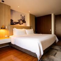 a bedroom with a large white bed and wooden cabinets at Quo Quality Hotel, Manizales