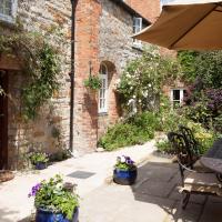 a patio with an umbrella and a table and chairs at The Old Kiln House, Shipston on Stour