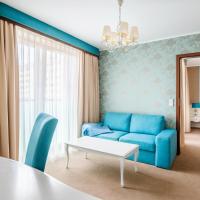 a room with a blue couch and a bed at Hotel Opole Centrum