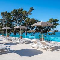 a row of chairs and umbrellas next to a swimming pool at Valamar Meteor Hotel, Makarska