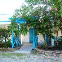a house with a blue door and a tree at The Lodge - Antigua, English Harbour Town