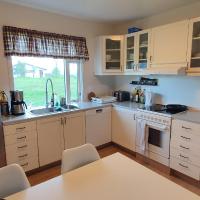 a small kitchen with white cabinets and a table at Efri Bru, Selfoss