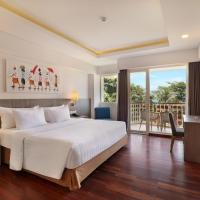a bedroom with a large white bed and a balcony at ASTON Canggu Beach Resort