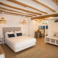 a bedroom with a white bed and a dining room at Savoy, Alcoy