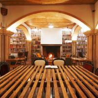 a library with a wooden table and a fireplace at The Literary Man Obidos Hotel, Óbidos