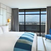 a hotel room with a bed and a blue chair at Sofitel Abidjan Hotel Ivoire