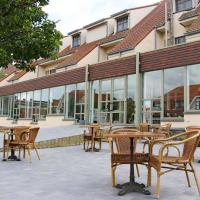a patio with tables and chairs in front of a building at Hotel Les Dunes, De Haan