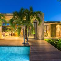 a house with a swimming pool and palm trees at Villa Islander, Providenciales