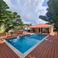a swimming pool with a wooden deck and a house at Pimento Villa - private villa and pool, Jolly Harbour