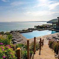 a house with a swimming pool next to the ocean at Carbis Bay and Spa Hotel, St Ives