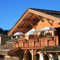 a building with a balcony with umbrellas on it at Chalet-Hôtel Les Cimes, Le Grand-Bornand