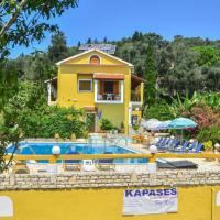 a yellow house with a swimming pool in front of it at Kapases Studios & Apartments, Peroulades