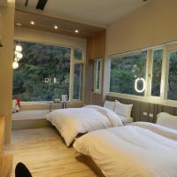 two beds in a room with two windows at 谷關明高溫泉 Mingao Hot Spring Resort, Heping