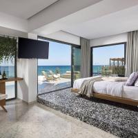 a bedroom with a bed and a view of the ocean at Dyo Suites, Rethymno