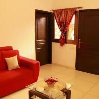 a living room with a red couch and a glass table at Residence Appartements Luxueux -Angre-ABIDJAN, Cocody