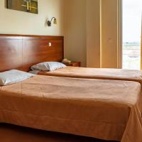 a hotel room with two beds and a window at Telis Hotel, Aigio