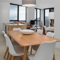 a dining room with a wooden table and white chairs at St Falls Resort, Falls Creek