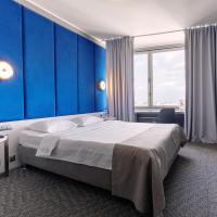 a hotel room with a bed and a blue wall at Astrus Hotel Moscow