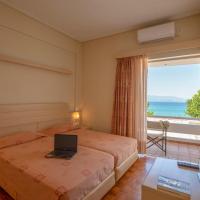 a room with two beds and a window with a laptop at Hotel Kypreos, Kamena Vourla